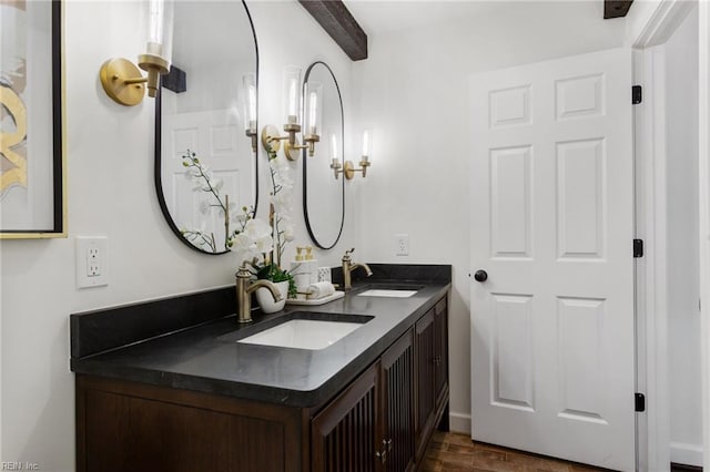 full bathroom with a sink, double vanity, and beam ceiling