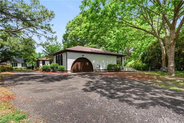 view of property exterior featuring aphalt driveway and an attached garage