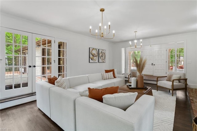 living area featuring french doors, ornamental molding, dark wood-type flooring, a baseboard radiator, and a notable chandelier