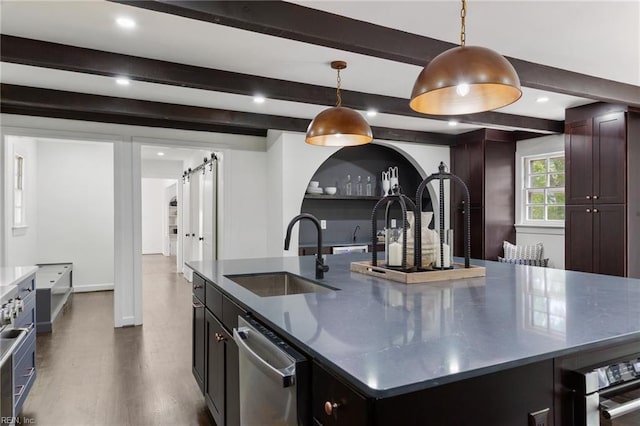 kitchen with a sink, stainless steel dishwasher, a barn door, beamed ceiling, and a large island