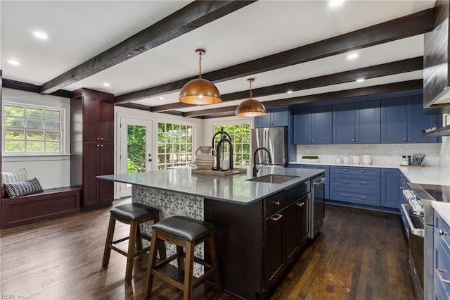 kitchen featuring dark wood-style flooring, stainless steel appliances, tasteful backsplash, and a sink