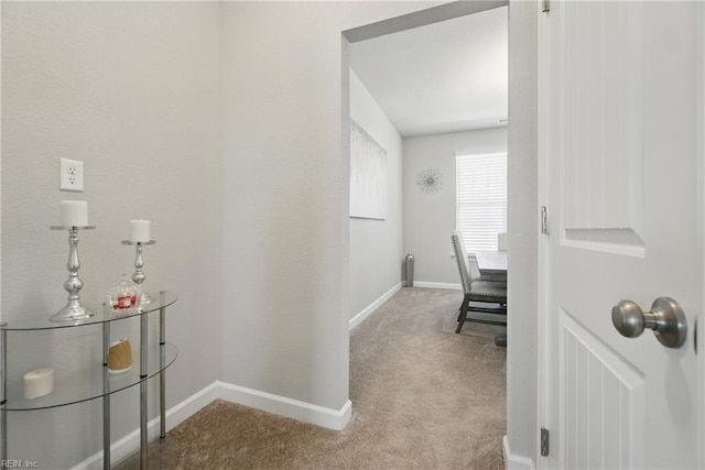 hall featuring baseboards and carpet