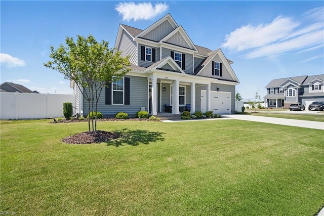 craftsman inspired home featuring concrete driveway, board and batten siding, fence, and a front yard