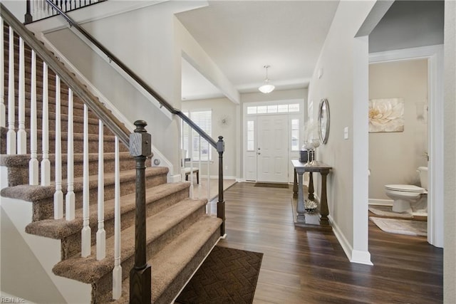 entrance foyer featuring dark wood-type flooring, baseboards, and stairs
