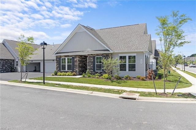 view of front facade featuring a garage, concrete driveway, a front lawn, board and batten siding, and a shingled roof