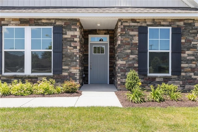 view of exterior entry with stone siding and board and batten siding