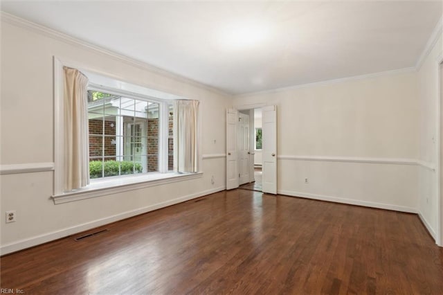 spare room with crown molding, visible vents, plenty of natural light, and wood finished floors