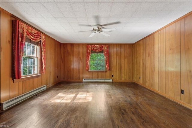 empty room featuring a ceiling fan, a baseboard radiator, baseboard heating, baseboards, and wood finished floors