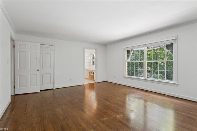 interior space with baseboards, ensuite bath, crown molding, and wood finished floors