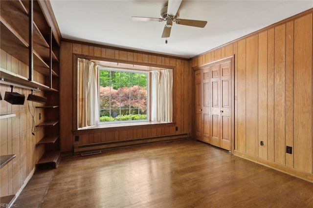 unfurnished bedroom featuring wood walls, crown molding, and wood finished floors