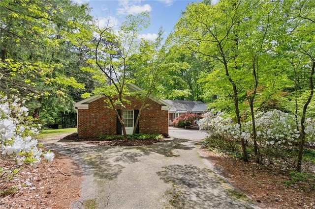 view of home's exterior featuring brick siding and driveway
