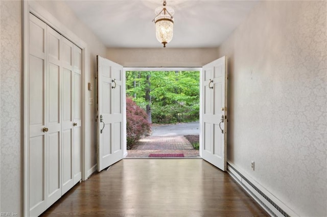 entrance foyer featuring a baseboard heating unit and dark wood-style flooring