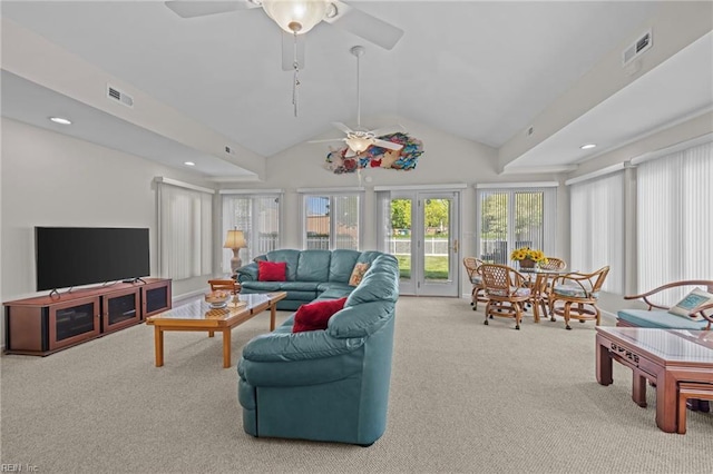 carpeted living area with a wealth of natural light, visible vents, and a ceiling fan