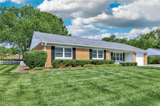 single story home featuring an attached garage, brick siding, and a front yard