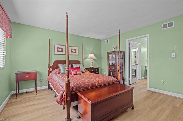 bedroom featuring baseboards, visible vents, and wood finished floors