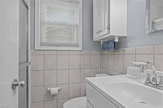 full bath featuring toilet, tile walls, and vanity