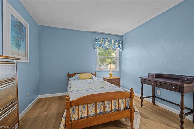 bedroom featuring baseboards and wood finished floors