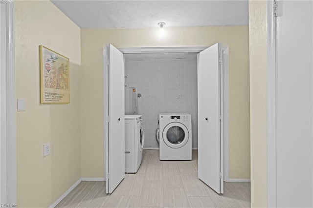 laundry area featuring washing machine and dryer, baseboards, and laundry area