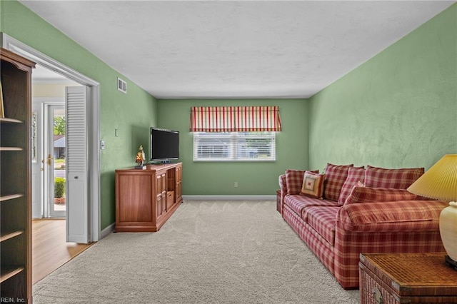 living room featuring carpet floors, baseboards, and visible vents