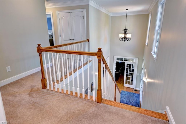 stairway with carpet floors, a chandelier, crown molding, and baseboards