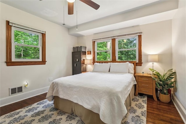 bedroom with baseboards, dark wood-style floors, visible vents, and multiple windows