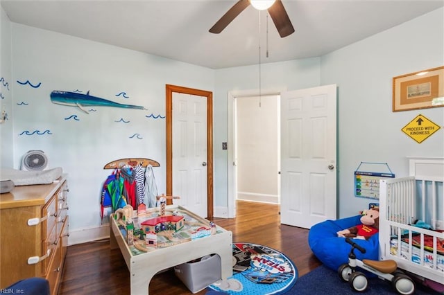 recreation room featuring baseboards, a ceiling fan, and wood finished floors