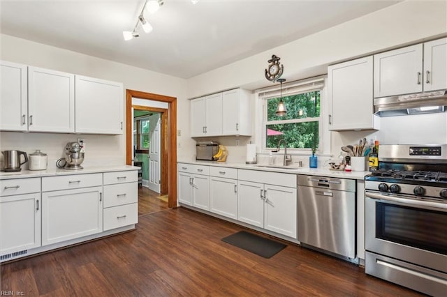 kitchen featuring under cabinet range hood, visible vents, a sink, white cabinets, and appliances with stainless steel finishes