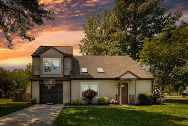 traditional home featuring concrete driveway, a yard, and an attached garage