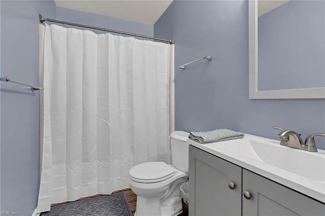 full bath featuring toilet, a shower with shower curtain, wood finished floors, and vanity