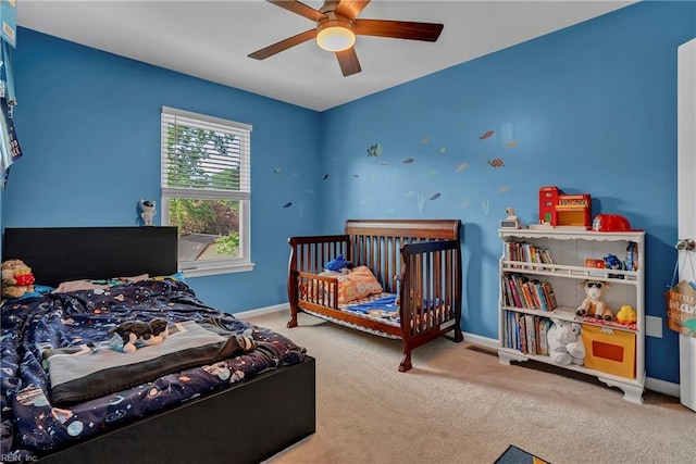 carpeted bedroom featuring baseboards and a ceiling fan