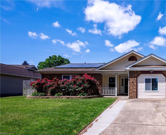 single story home featuring a front lawn, solar panels, brick siding, and covered porch