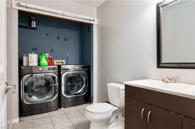 bathroom with washing machine and clothes dryer, toilet, tile patterned flooring, and vanity