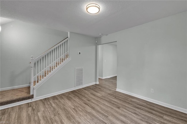 912 W 31st St, Norfolk, VA 23508 - unfurnished living room featuring stairs, wood finished floors, a textured ceiling, visible vents, and baseboards
