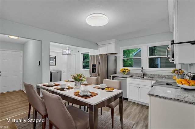 912 W 31st St, Norfolk, VA 23508 - kitchen featuring a sink, light wood-type flooring, white cabinetry, light stone countertops, and appliances with stainless steel finishes