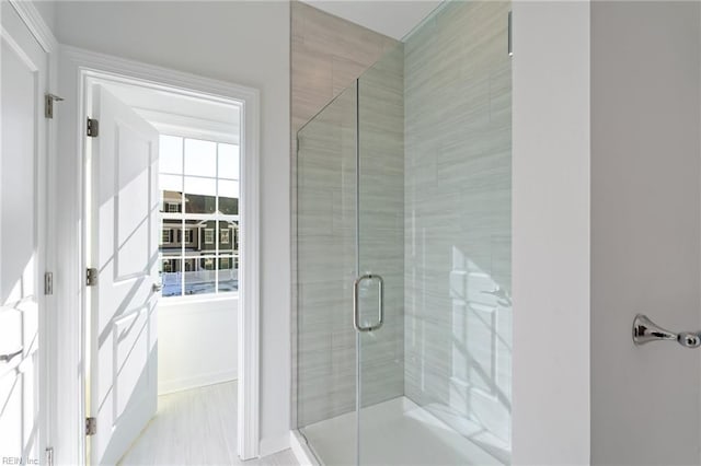 bathroom with baseboards and a shower stall