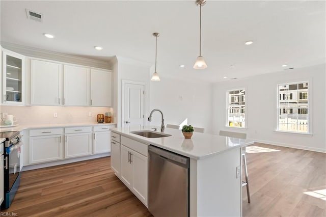 kitchen featuring white cabinetry, light wood-style flooring, appliances with stainless steel finishes, and a sink