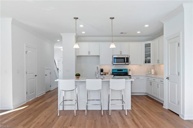 kitchen featuring stainless steel appliances, tasteful backsplash, white cabinets, and light wood-style floors