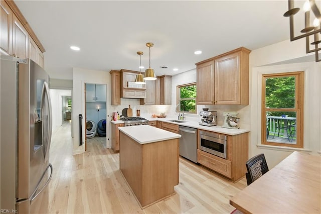 1601 Upton Pl, Suffolk, VA 23433 - kitchen featuring separate washer and dryer, light wood-style flooring, light countertops, a center island, and appliances with stainless steel finishes