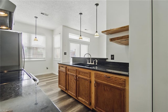 kitchen featuring a sink, freestanding refrigerator, plenty of natural light, and wood finished floors