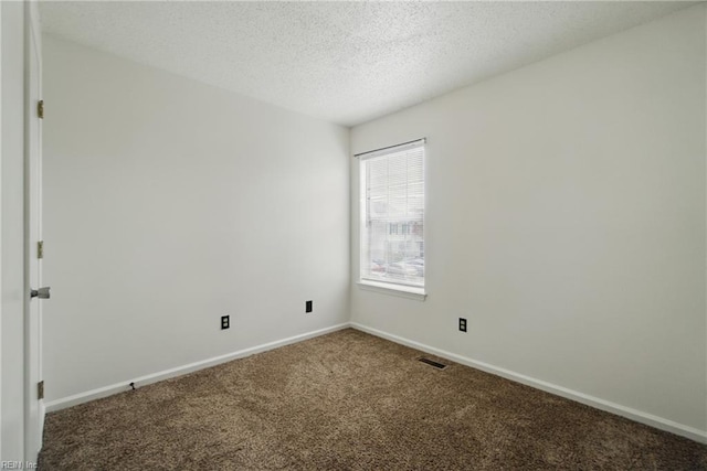 empty room with baseboards, a textured ceiling, visible vents, and carpet floors