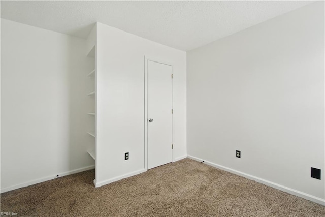 unfurnished bedroom with a textured ceiling, baseboards, and carpet floors