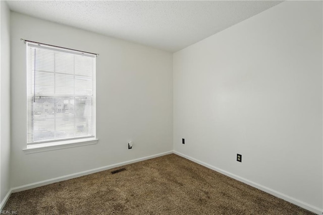 unfurnished room featuring baseboards, a textured ceiling, and carpet