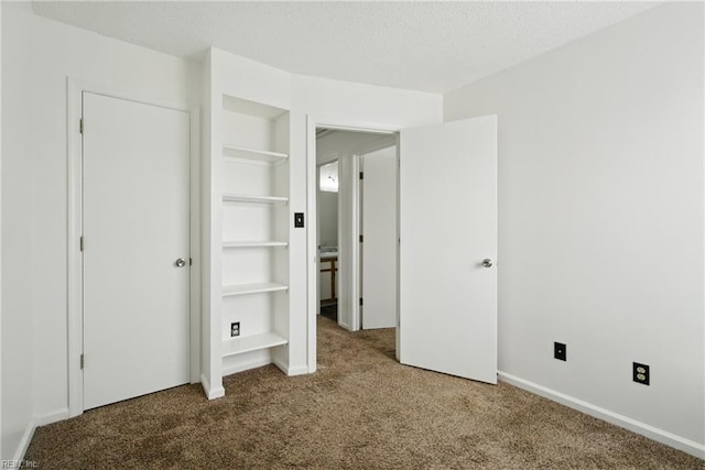 unfurnished bedroom featuring carpet and a textured ceiling
