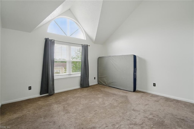 empty room with baseboards, carpet, and vaulted ceiling