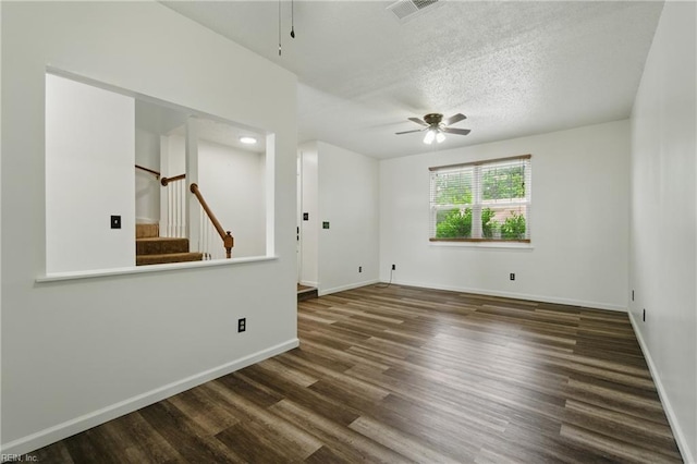unfurnished room featuring stairs, wood finished floors, visible vents, a ceiling fan, and baseboards