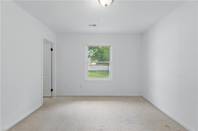 carpeted empty room featuring baseboards and visible vents