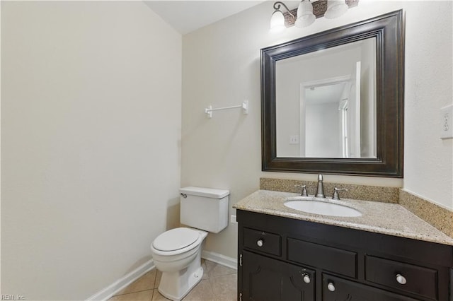 bathroom featuring toilet, tile patterned flooring, vanity, and baseboards