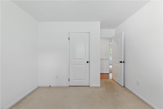 unfurnished bedroom with carpet and baseboards