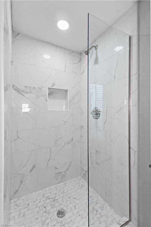 bathroom with a marble finish shower
