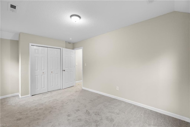 unfurnished bedroom with carpet floors, baseboards, and visible vents
